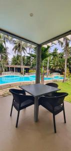 a ping pong table and two chairs on a patio at Pili Beach Resort Agmanic in Santa Fe