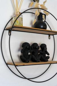 a group of black monkey figurines on a shelf at AppartHotel le Nid Marin in Aytré