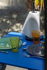 a blue table with two cups and plates and a napkin at AppartHotel le Nid Marin in Aytré