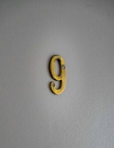 a gold number eight on a white wall at AppartHotel le Nid Marin in Aytré