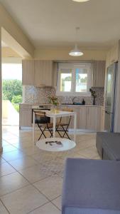 a living room with a table and a kitchen at Venetiko rooms in Chios