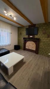 a living room with a white coffee table and a tv at HIT- house in Slavske