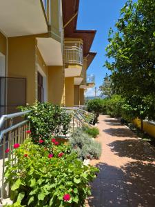 a building with red flowers and a walkway at Sirman Apart Hotel in Sarigerme
