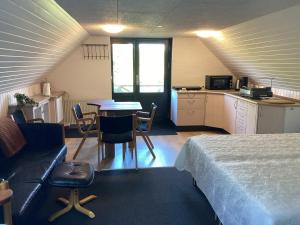 a room with a bed and a table and a kitchen at Enghaven Bed & Kitchen in Ansager