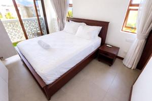 a bed with white sheets and pillows in a bedroom at Sultan palace Luxury Two bedrooms in Kilifi