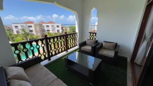 a living room with a balcony with a couch and chairs at Sultan palace Luxury Two bedrooms in Kilifi +2 photos