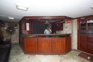 a man taking a picture in a mirror in a bar at Hotel Penguin International in Kolkata