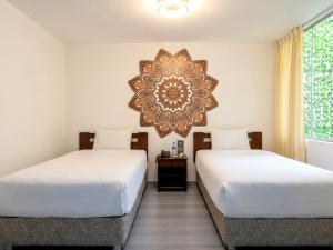 two beds in a room with a mirror on the wall at Mandala Rooms & Services in Arequipa +53 photos