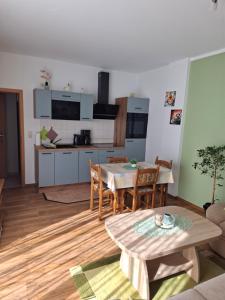 a living room with a table and a kitchen at Ferienwohnung Morgensonne in Ueckeritz