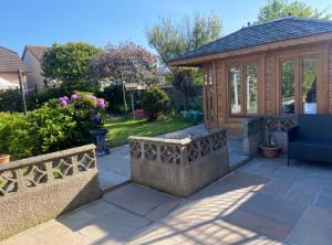 a gazebo with a bench and a blue chair at Preston Villa, spacious ground floor apartment in Buckie
