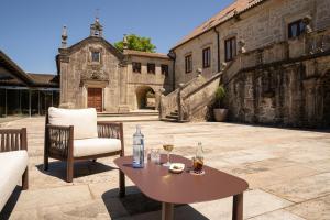 a table and a chair on a patio at Pazo Arretén in Padrón