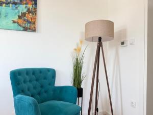 a blue chair in a living room with a lamp at Apartment Alto in Sarajevo +32 photos