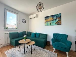 a living room with a green couch and two chairs at Apartment Alto in Sarajevo
