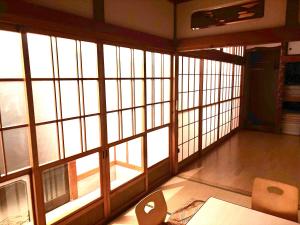 an empty room with large windows in a building at Oharama House in Nasushiobara