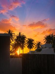 a sunset with palm trees in front of a building at Villa GAÏA - Luxury Tropical Villa - Private Pool in Lamai
