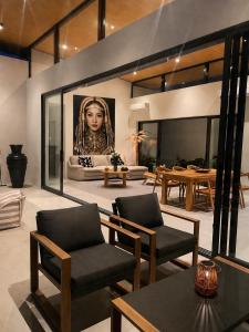 a living room with a picture of a woman at Villa GAÏA - Luxury Tropical Villa - Private Pool in Lamai