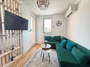 a living room with a green couch and a table at Apartment Alto in Sarajevo