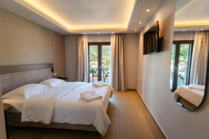 a hotel room with a bed and a mirror at Filakas in Syvota
