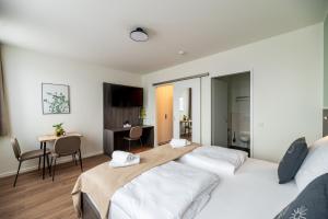 a hotel room with two beds and a desk at Limehome Bremerhaven Kantstraße in Bremerhaven