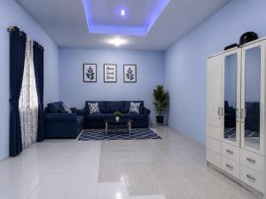 a living room with a blue couch and a table at Bkc Home's 101 in Mataram