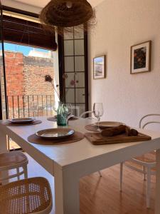 a white table with two plates and a glass at Apartamento Carmen in Macastre