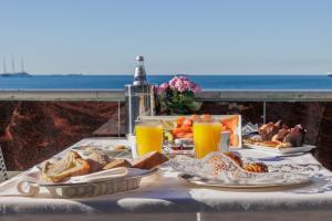 a table with plates of food and orange juice at Grand Apartment Sissi in Trieste