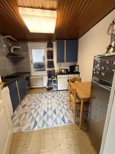 a kitchen with blue cabinets and a wooden table at Ferienwohnung Adenau in Adenau