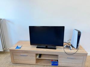 a flat screen tv sitting on top of a wooden entertainment center at Ferienwohnung Adenau in Adenau