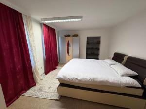 a bedroom with a bed and red curtains at Ferienwohnung Adenau in Adenau