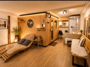 a living room with a couch and a bed and a fireplace at Chalet Woidzauber in Zwiesel