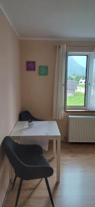 a table and a chair in a room with a window at Seeblick Krippenstein2 in Obertraun