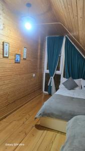 a bedroom with a bed with a blue curtain at Luxury Cottage Resort in Patara-Tsemi