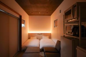 a small room with two beds and a couch at SEN RETREAT HONGU - Kumano Kodo Gateway in Tanabe