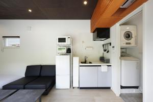 a living room with a couch and a kitchen at SEN RETREAT HONGU - Kumano Kodo Gateway in Tanabe