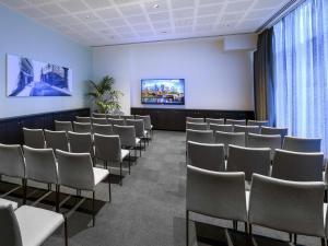 a waiting room with chairs and a projection screen at ibis Melbourne Central in Melbourne