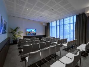 a waiting room with chairs and a flat screen tv at Novotel Melbourne Central in Melbourne