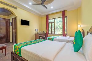 a hotel room with two beds and a window at Treebo Kaler Hotel & Resorts in Nainital +46 photos