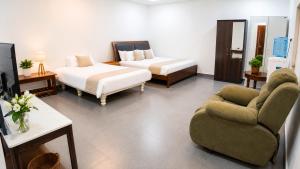 a room with two beds and a couch and a tv at Gardens by Lotels in Madambakkam