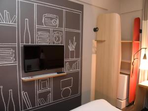 a bedroom with a chalkboard wall with a tv at ibis Tatui in Tatuí
