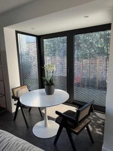 a room with a table and chairs and windows at koetshuis in Ieper +35 photos
