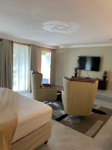a bedroom with a bed and a desk and chairs at Green Whisper BnB in Umtali