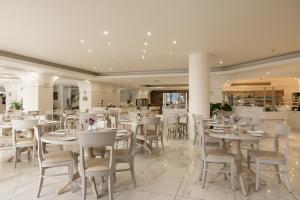 a dining room with white tables and chairs at Vantaris Palace in Georgioupolis