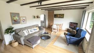 a living room with a couch and a tv at Ferienwohnung am Badesee in Arrach