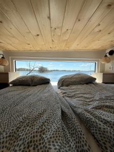 two beds in a bedroom with a large window at Ośrodek Dalpol in Prażmowo