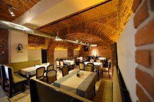 a dining room with tables and chairs and a brick wall at Pensiunea Antique in Târgu Jiu +28 photos