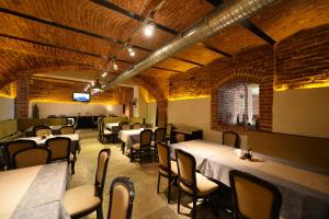 a dining room with tables and chairs and brick walls at Pensiunea Antique in Târgu Jiu