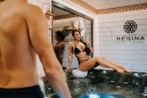 a man looking at a model in a mirror in a bathtub at Willa Regina II Resort & SPA in Zakopane