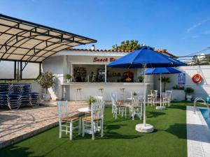 a patio with tables and chairs and an umbrella at Smart Accomodation Rhodes by GHH in Rhodes Town