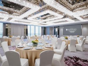 a ballroom with tables and white chairs and a screen at Pullman Shanghai Qingpu Excellence in Shanghai +124 photos