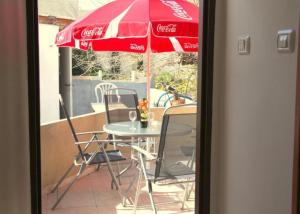 a table with chairs and a cocacola umbrella at Haifa Guest House in Haifa